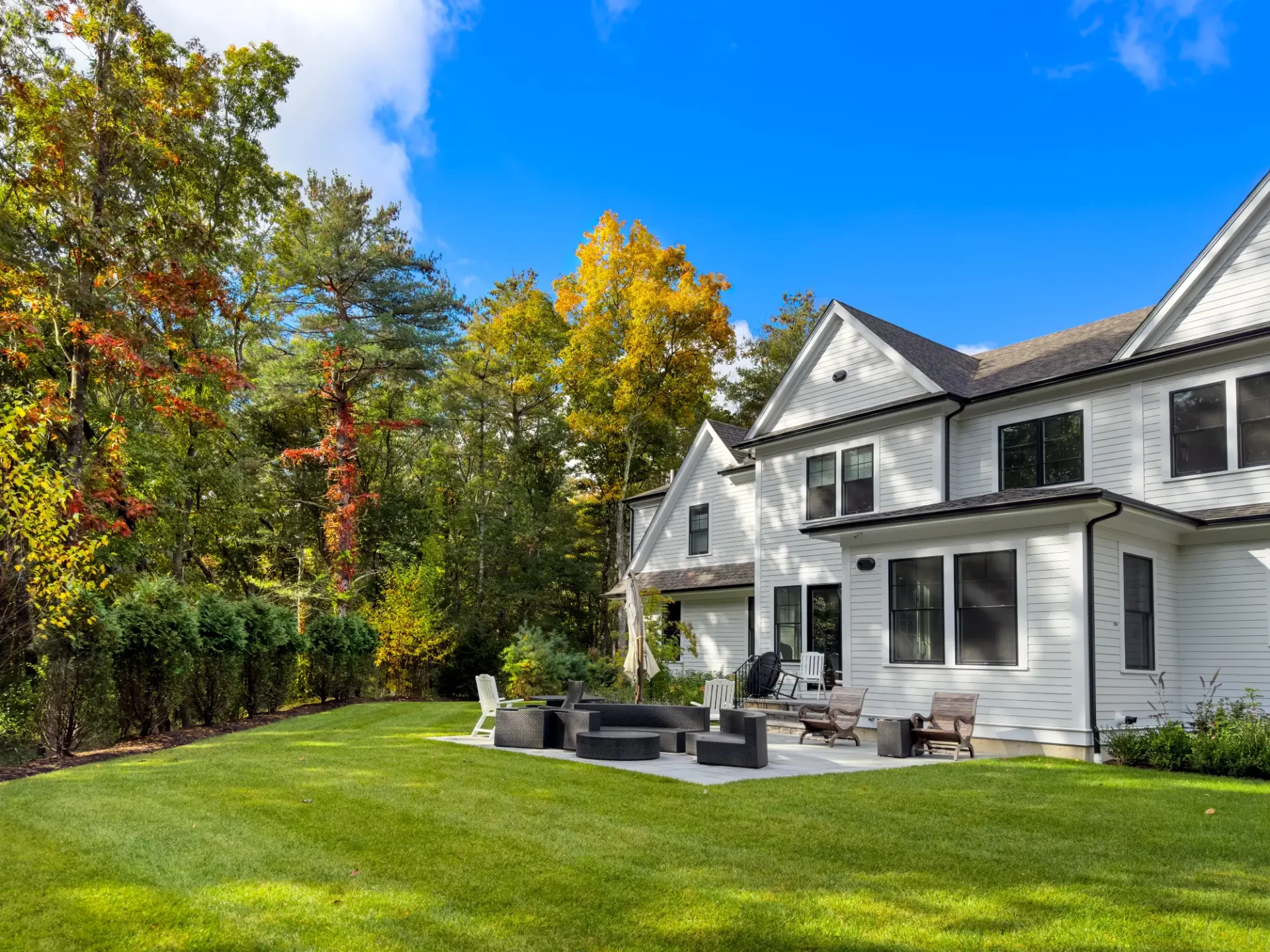 A large white house sitting in the middle of a yard.